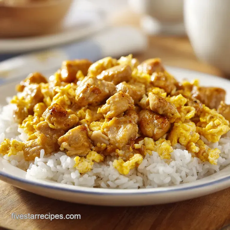 Neatly mounded golden rice and seared chicken in a white ceramic bowl, topped with sliced green onions and sesame seeds.